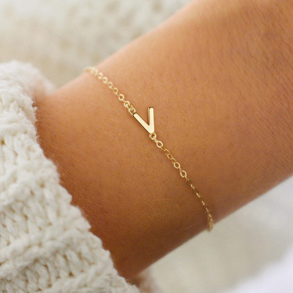 Gold initial V bracelet at the wrist - Pulse and Glow