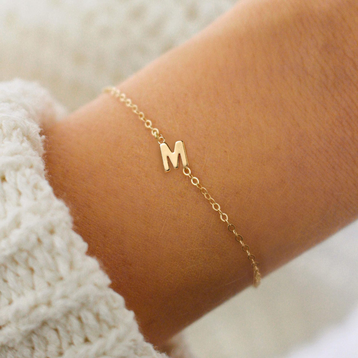 Gold initial W bracelet at the wrist - Pulse and Glow