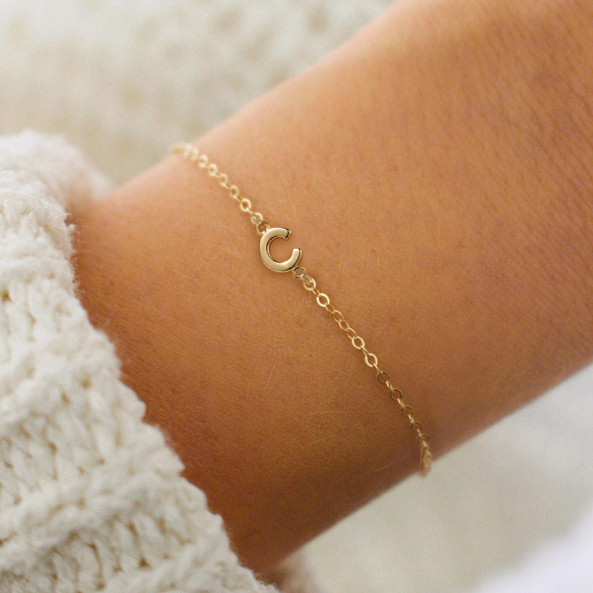 Gold initial C bracelet at the wrist - Pulse and Glow